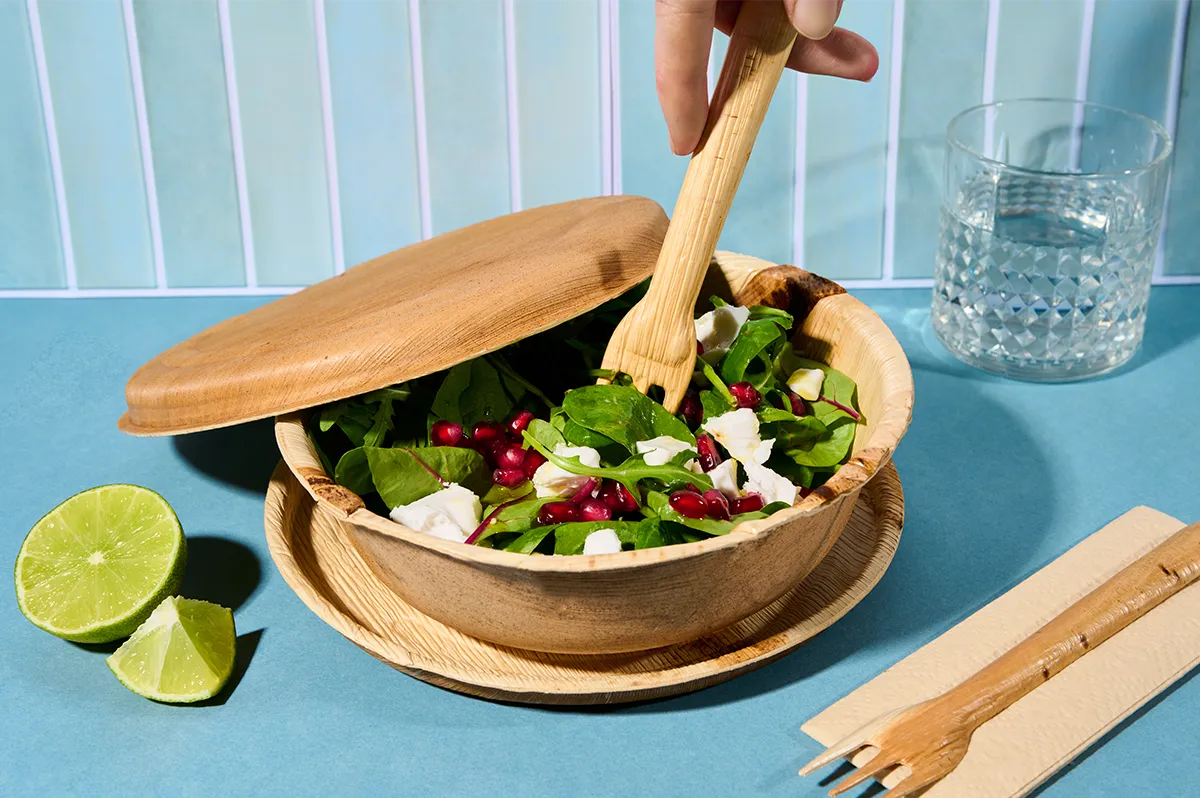 Anwendungsbeispiel SupaBowls Palmblatt-Bowl mit Deckel und Beilagensalat auf blauem Hintergrund