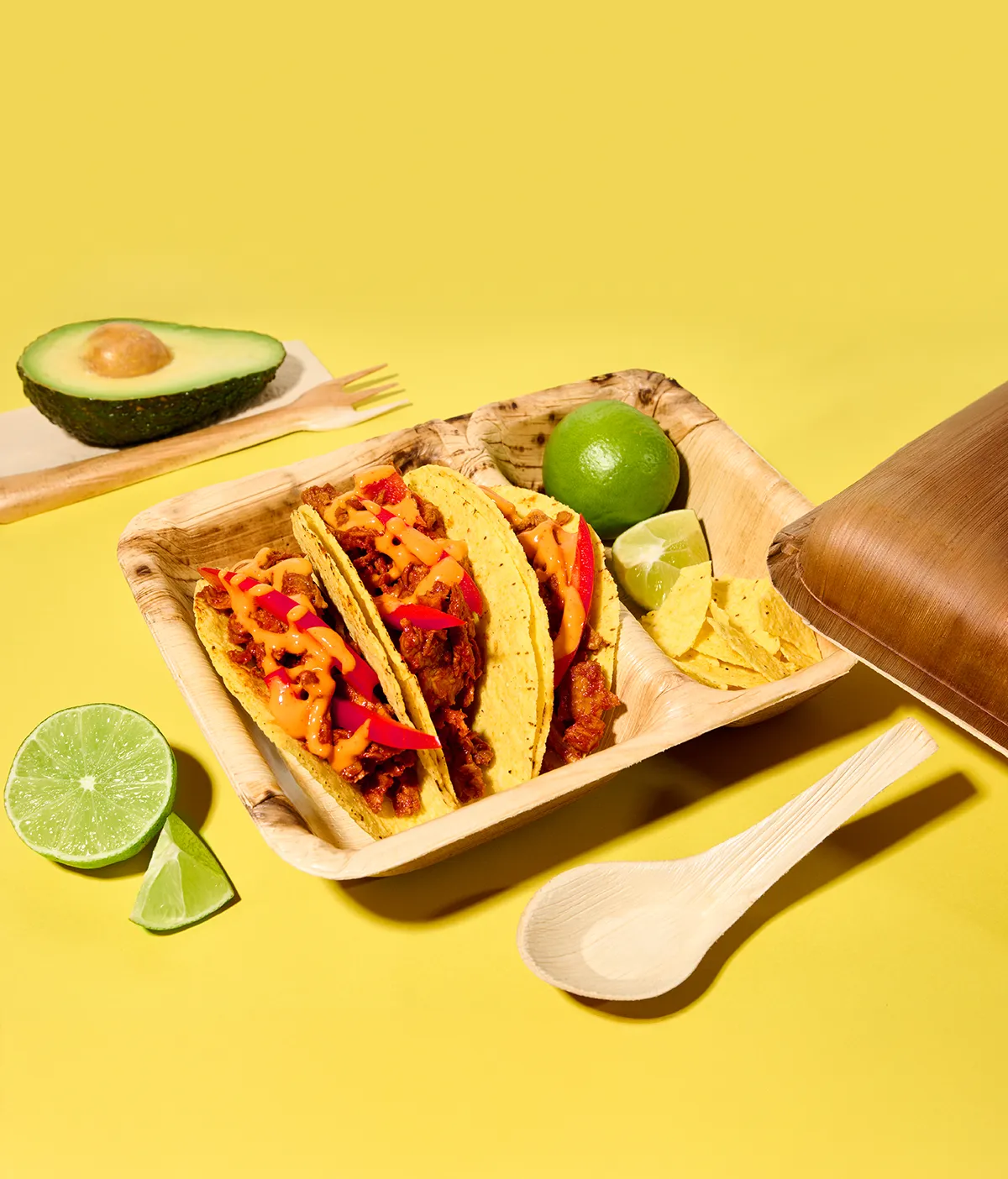 Anwendungsbeispiel Take-Away Palmblatt-Container mit zwei Kammern gefüllt mit Tacos auf gelbem Hintergrund